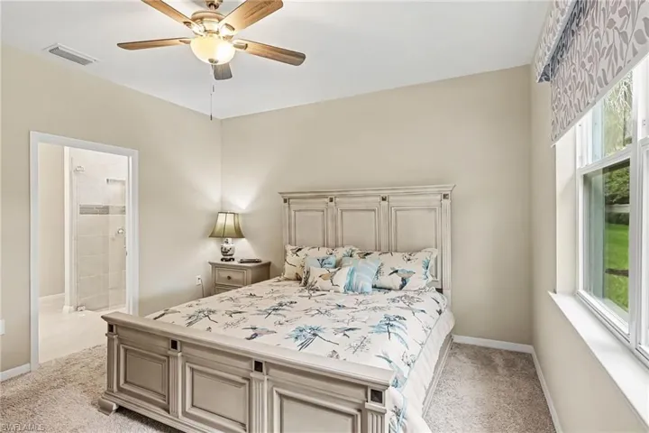 Plush carpeting, ceiling fan with integrated lighting, and a window with exterior views