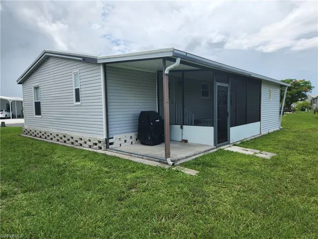 Rear view of property with a lawn