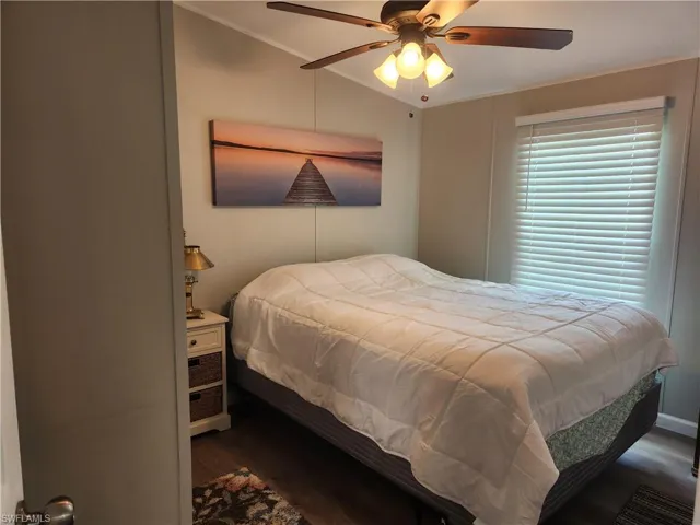 Bedroom featuring ceiling fan, dark hardwood / wood-style flooring, and ornamental molding
