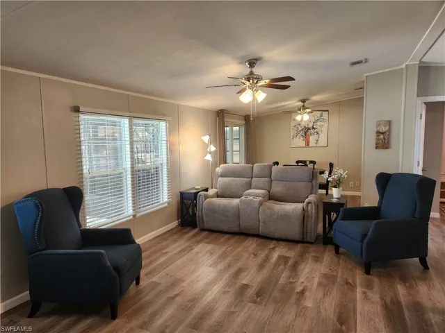 Living room with crown molding, ceiling fan, and hardwood / wood-style floors