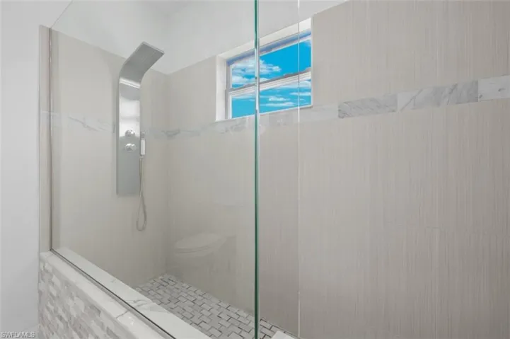 Bathroom featuring walk in shower and toilet