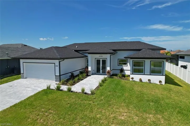 View of front of home featuring a garage and a front yard