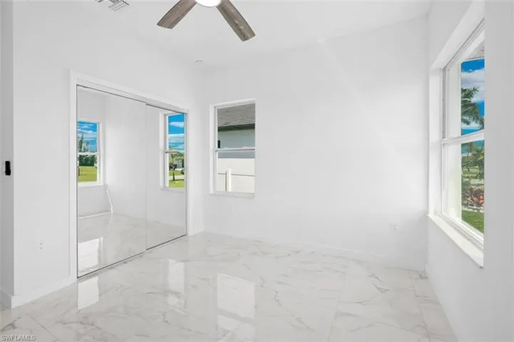 Tiled spare room with ceiling fan and a wealth of natural light