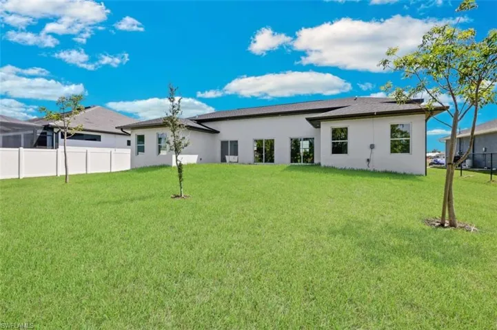 Rear view of property with a lawn