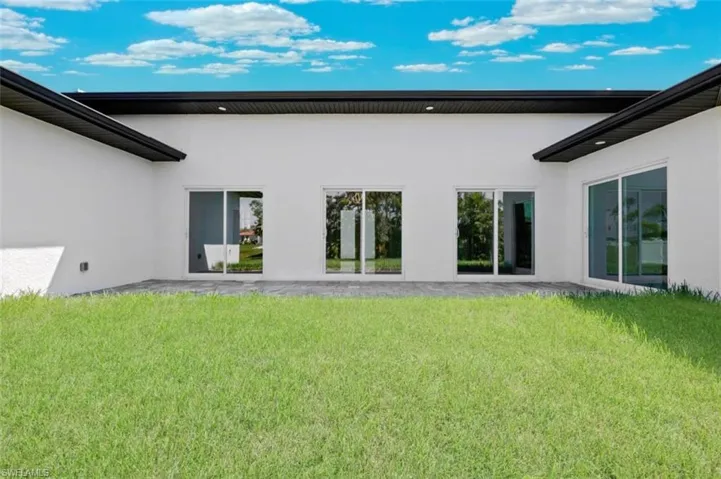 Rear view of house featuring a lawn