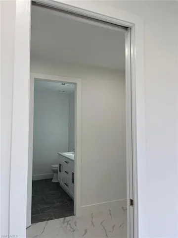 Corridor featuring dark tile flooring