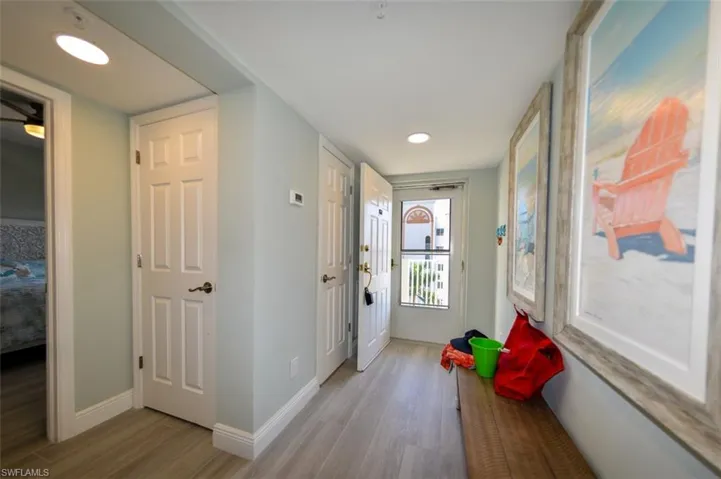 UNIT ENTRANCE.  CONVENIENT BENCH IS ALSO PART OF THE DINING TABLE SET, SO IT DOES DOUBLE DUTY.  ENTRANCE TO GUEST BEDROOM IS TO LEFT. PORCELAIN TILE WOOD-LOOK PLANK TILE IS THROUGHOUT THE UNIT.  ON THE OTHER SIDE OF THE WALL TO THE RIGHT IS THE KITCHEN.