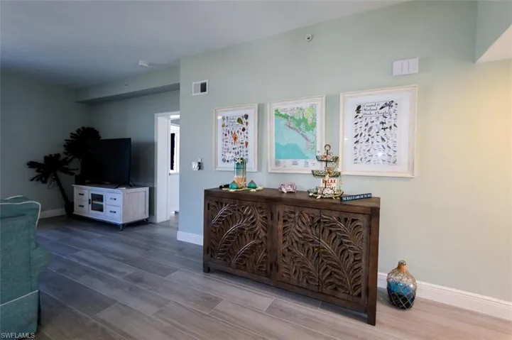 DINING AREA SHOWING ENTRANCE TO OWNER'S SUITE.  WOOD-LOOK PORCELAIN TILE PLANK FLOORING.