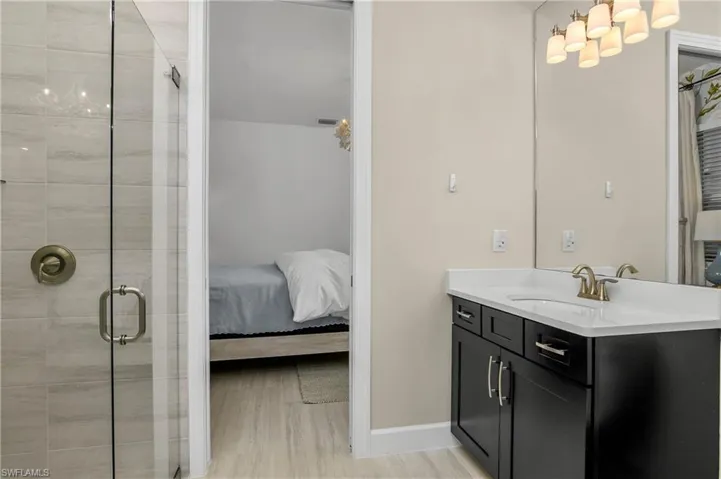 Bathroom featuring hardwood / wood-style flooring, an enclosed shower, and vanity
