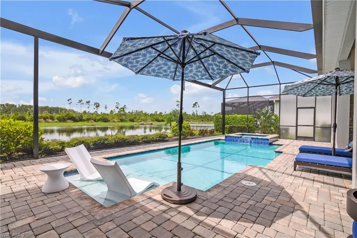 View of swimming pool featuring an in ground hot tub, glass enclosure, and a patio