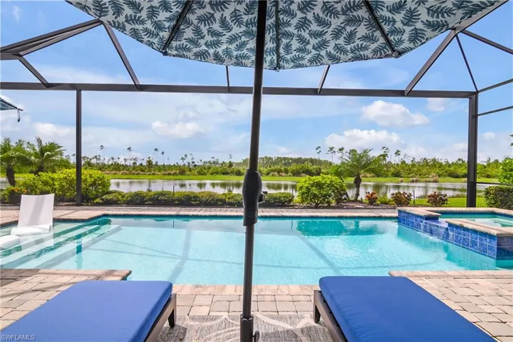 View of pool with an in ground hot tub, a patio area, and a lanai