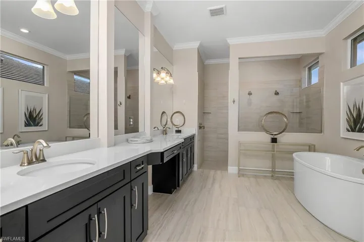 Bathroom featuring crown molding, vanity, and shower with separate bathtub