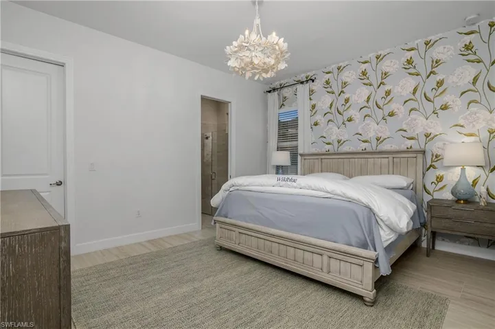 Bedroom featuring a chandelier and ensuite bath