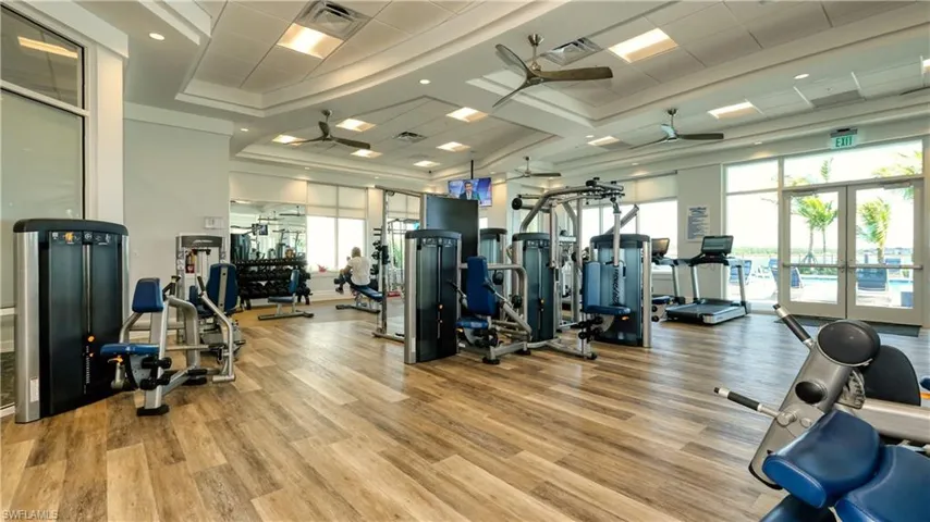 Gym featuring ceiling fan, french doors, and light hardwood / wood-style floors