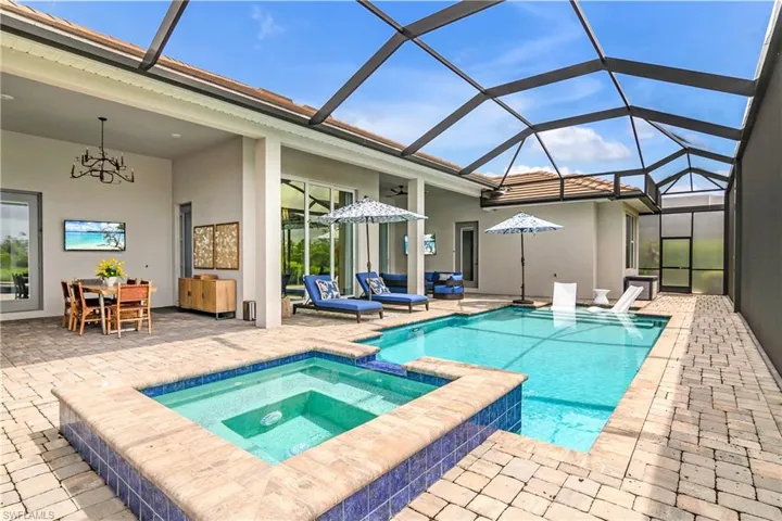 View of pool featuring a lanai, an in ground hot tub, a patio, and an outdoor hangout area
