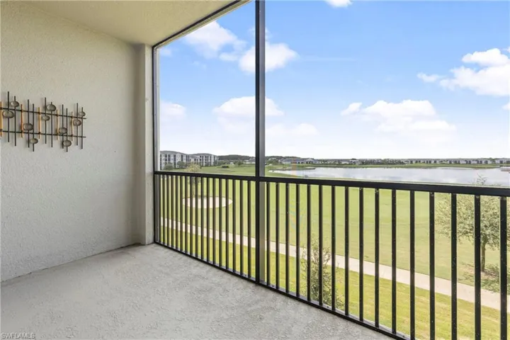 Balcony featuring a sunroom, a water view, and golf course view