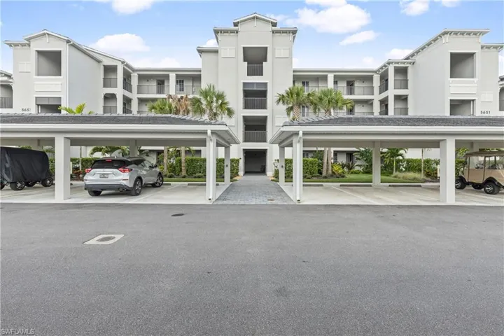 View of apartment building / complex with covered parking