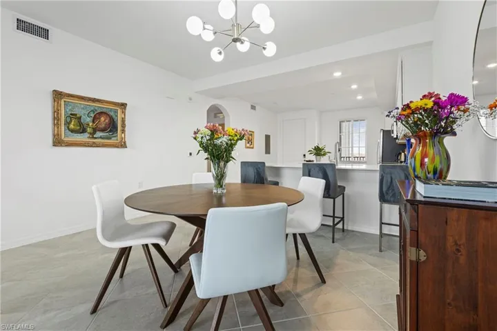 Dining room with recessed lighting, a chandelier, light tile patterned floors, and arched walkways