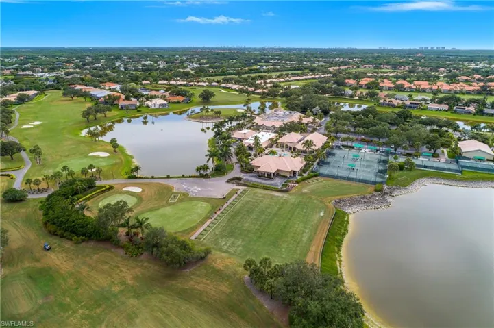 Aerial view of property and surrounding area featuring a nearby body of water, nearby suburban area, and a golf club