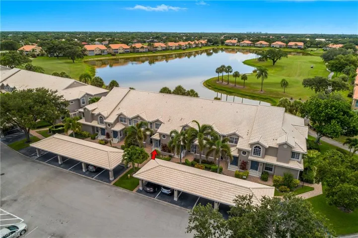 Aerial view of residential area featuring a golf club and a nearby body of water