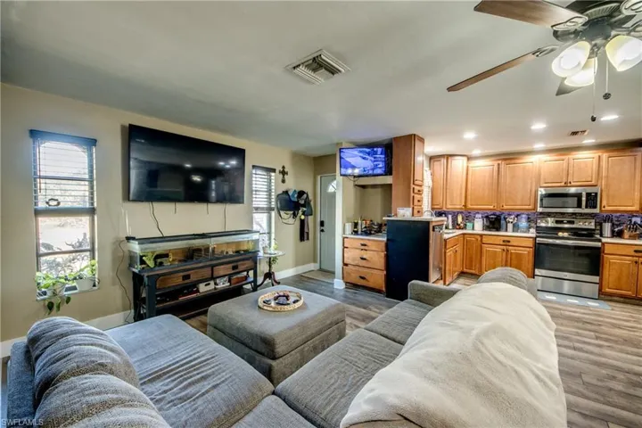 Living area with light wood-style floors, ceiling fan, and recessed lighting