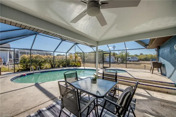 Swimming pool with a patio, a sunroom, a lanai, and outdoor dining area