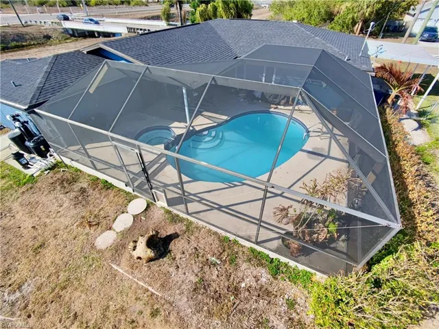 Outdoor pool with a sunroom and a lanai