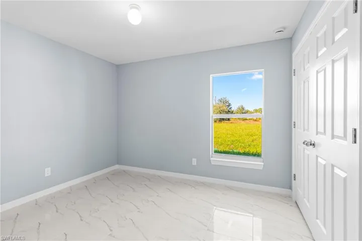 Unfurnished bedroom featuring light marble finish floors and a closet
