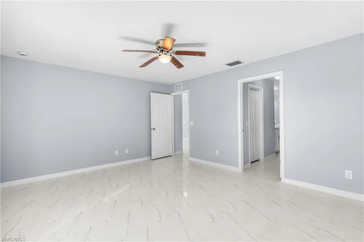 Unfurnished bedroom with a ceiling fan and light marble finish flooring