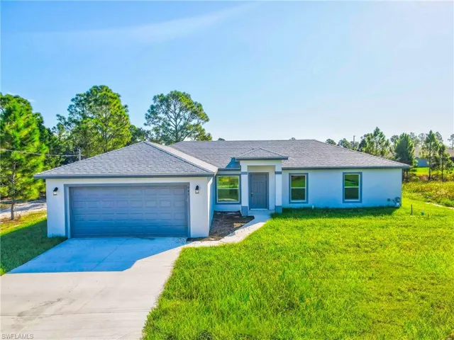 Single story home with a front lawn, concrete driveway, and stucco siding