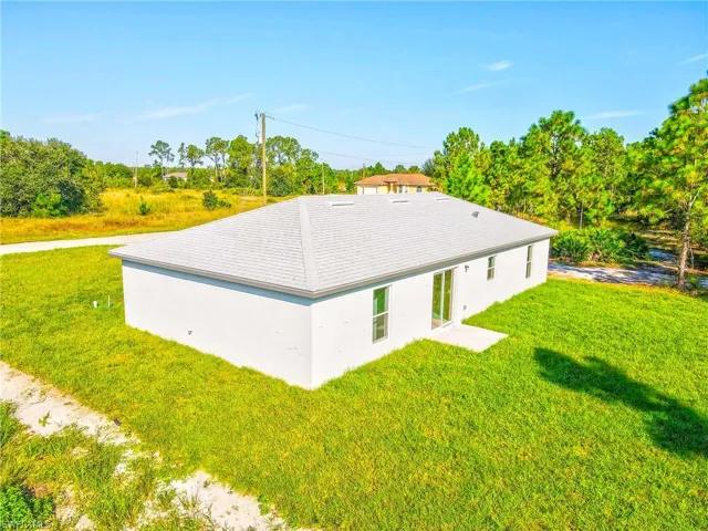 Back of property with a yard and stucco siding