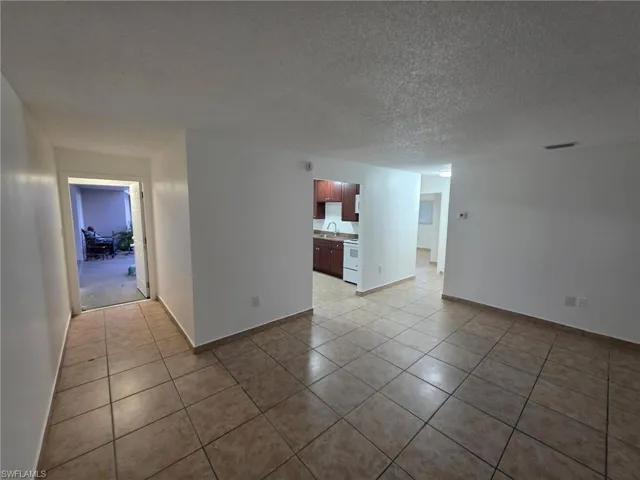 Unfurnished room featuring a textured ceiling and light tile patterned floors