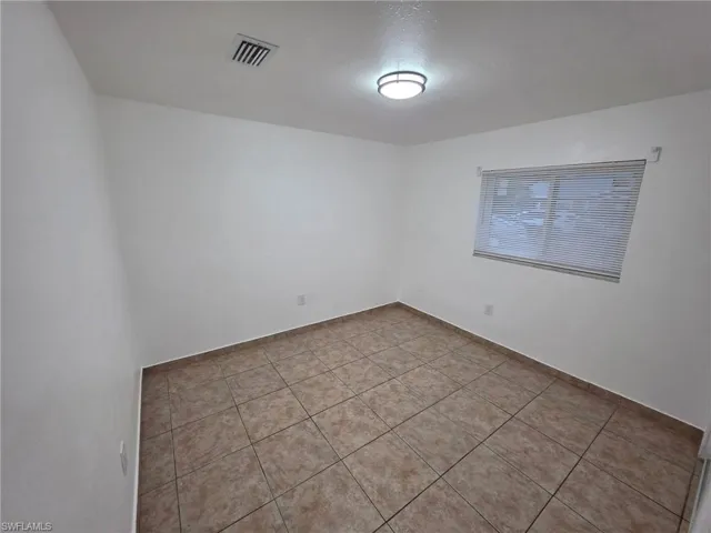 Unfurnished room with light tile patterned flooring and a textured ceiling