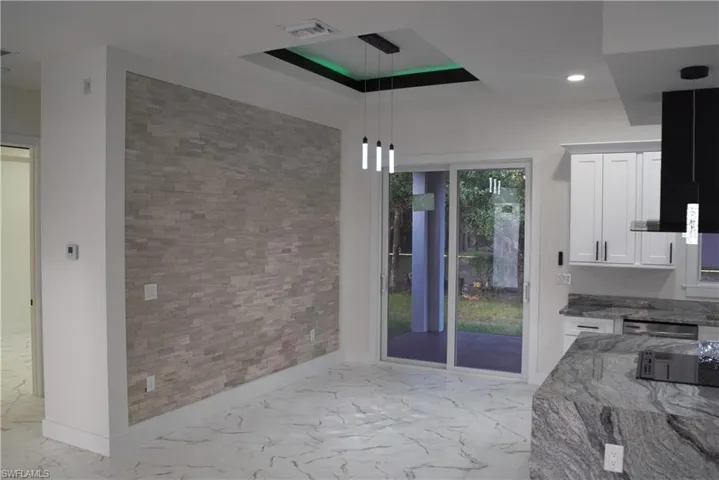 Spare room with light marble finish flooring, a tray ceiling, and recessed lighting