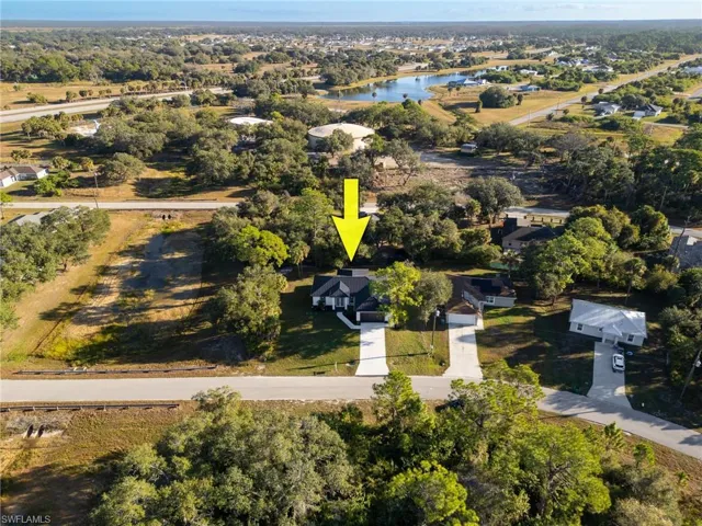 Aerial view of property and surrounding area with a nearby body of water
