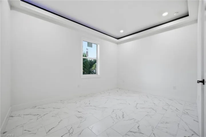 Empty room featuring light marble finish flooring and recessed lighting