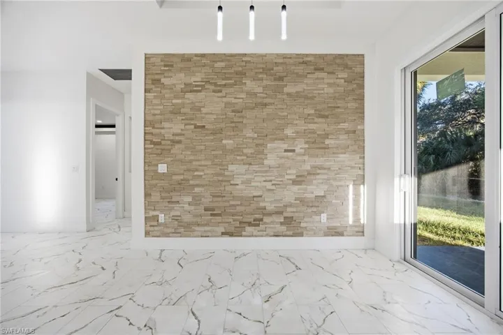 Empty room featuring marble look tile flooring and baseboards