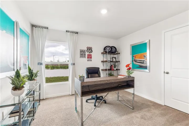 MODEL HOME - Office area featuring light carpet and baseboards