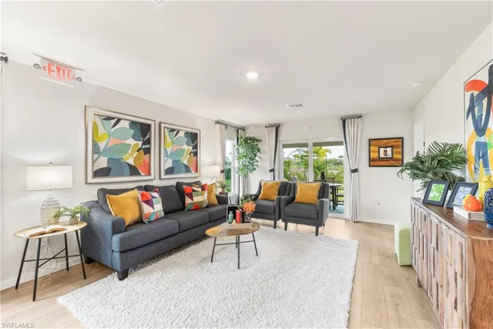 MODEL HOME - Living room with light wood-style flooring and baseboards