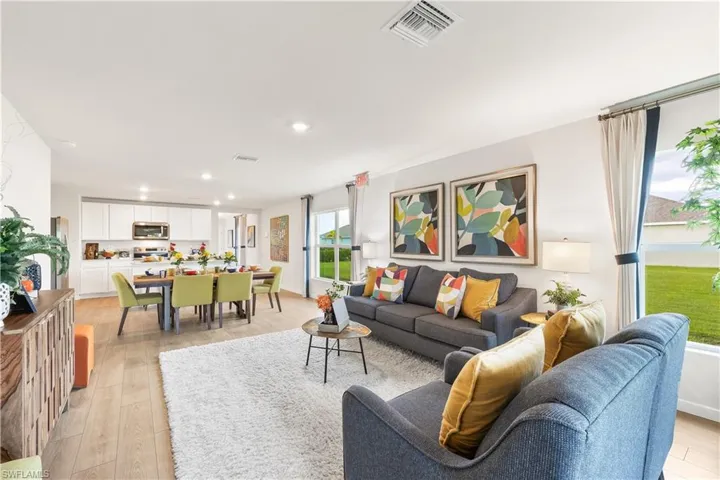 MODEL HOME - Living room with light wood finished floors and recessed lighting