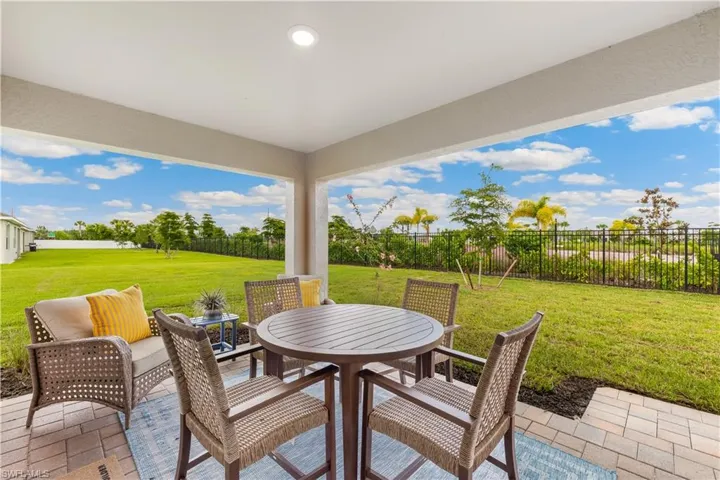 MODEL HOME - Fenced backyard with outdoor dining area and a patio area