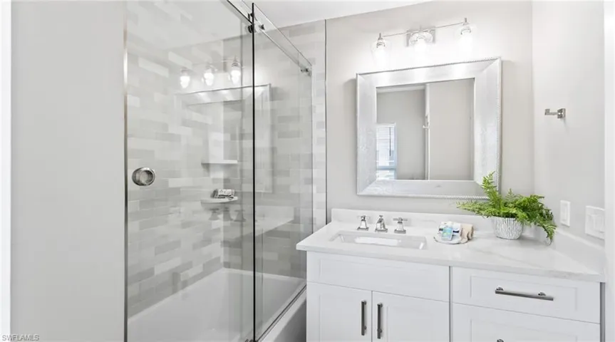 Full bath featuring bath / shower combo with glass door and vanity