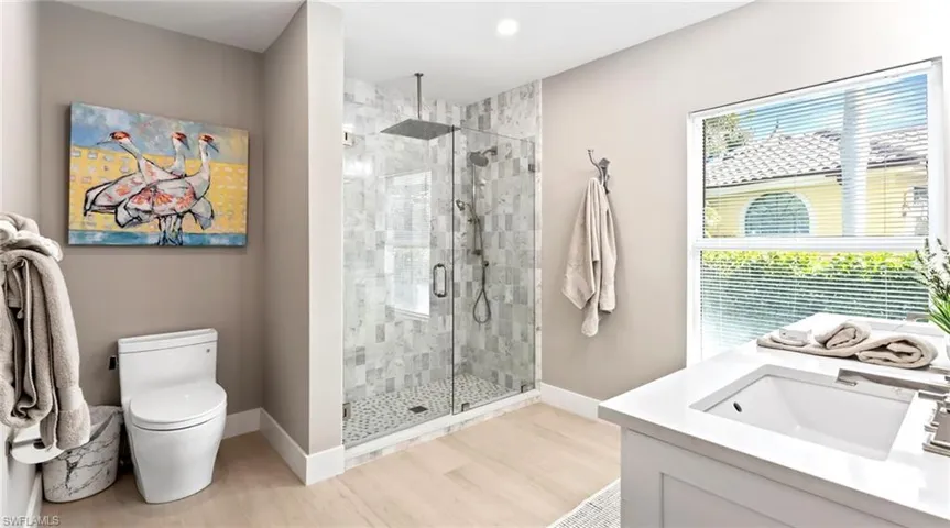 Bathroom featuring vanity, a stall shower, and light wood-style flooring