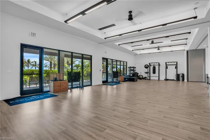 Exercise room with light hardwood / wood-style flooring and ceiling fan