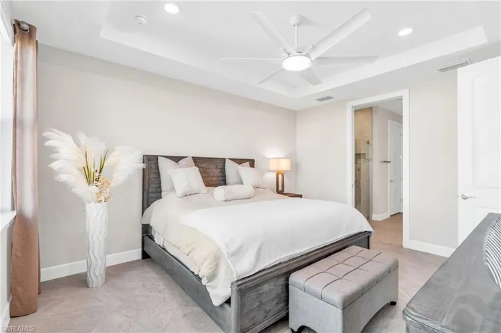 Bedroom featuring ceiling fan and a tray ceiling