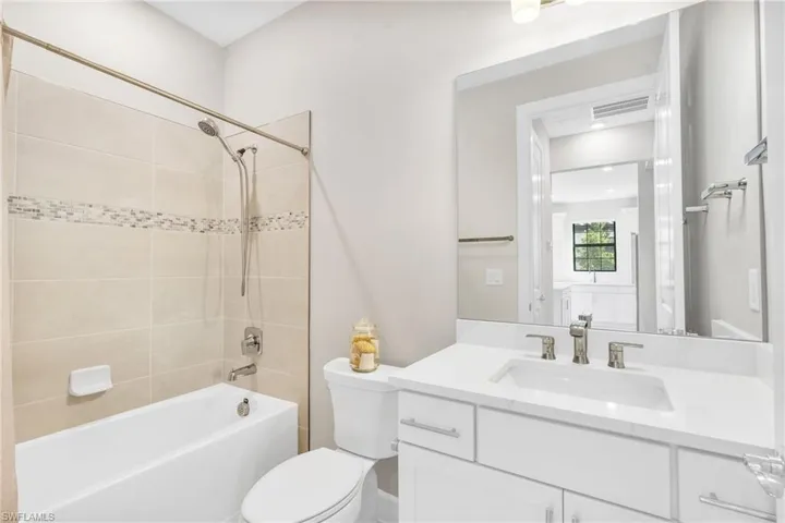Full bathroom with vanity, toilet, and tiled shower / bath