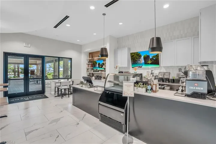 Kitchen featuring french doors, decorative backsplash, white cabinets, and decorative light fixtures