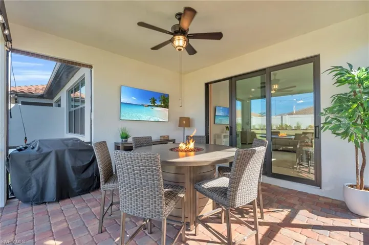 View of patio with ceiling fan, area for grilling, and a fire pit