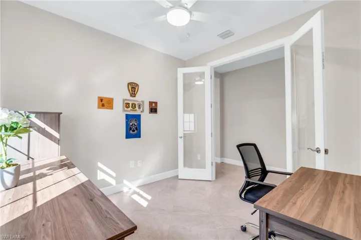Office with french doors and ceiling fan