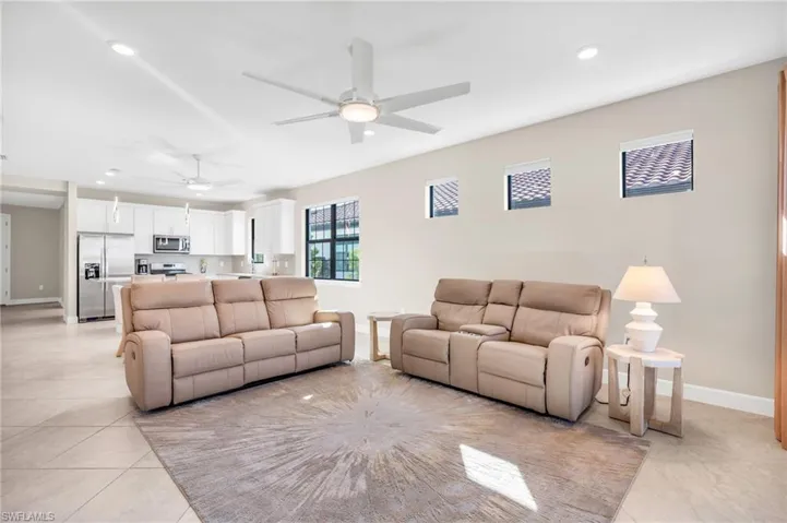 Living room featuring light tile patterned floors and ceiling fan